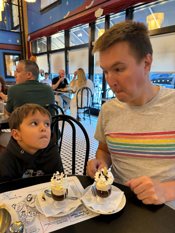 Logan and Mark making a silly face in front of two tiny sundaes.